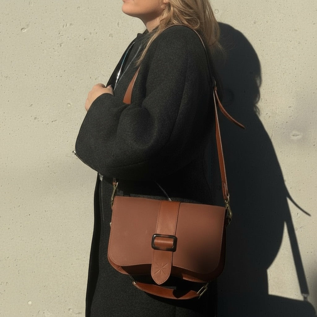 La Stella Rabat Baby Thara en cuir marron glacé, avec boucle en résine et doublure rouge. Sac bandoulière.